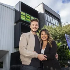 First time property investor holding paperwork outside an investment style townhouse in Melbourne