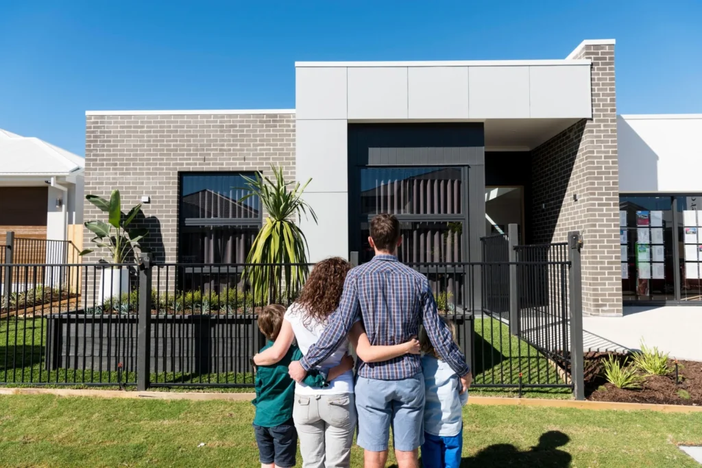 Couple holding house keys outside their new home after completing the home buying process in Australia