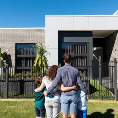 Couple holding house keys outside their new home after completing the home buying process in Australia
