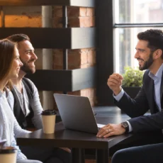 Client discussing home loan options with an independent mortgage broker across a desk instead of going directly to a bank