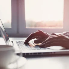 Homeowner comparing current home loan interest rates against refinancing options on a laptop at home