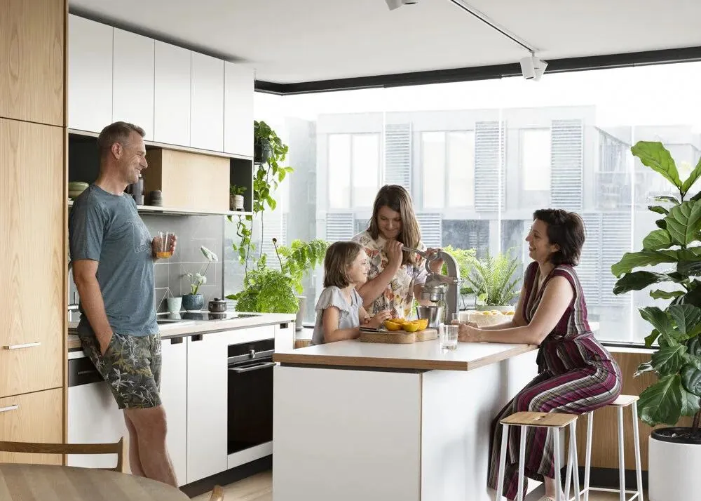 Family chatting around the kitchen island at home on a bright spring morning
